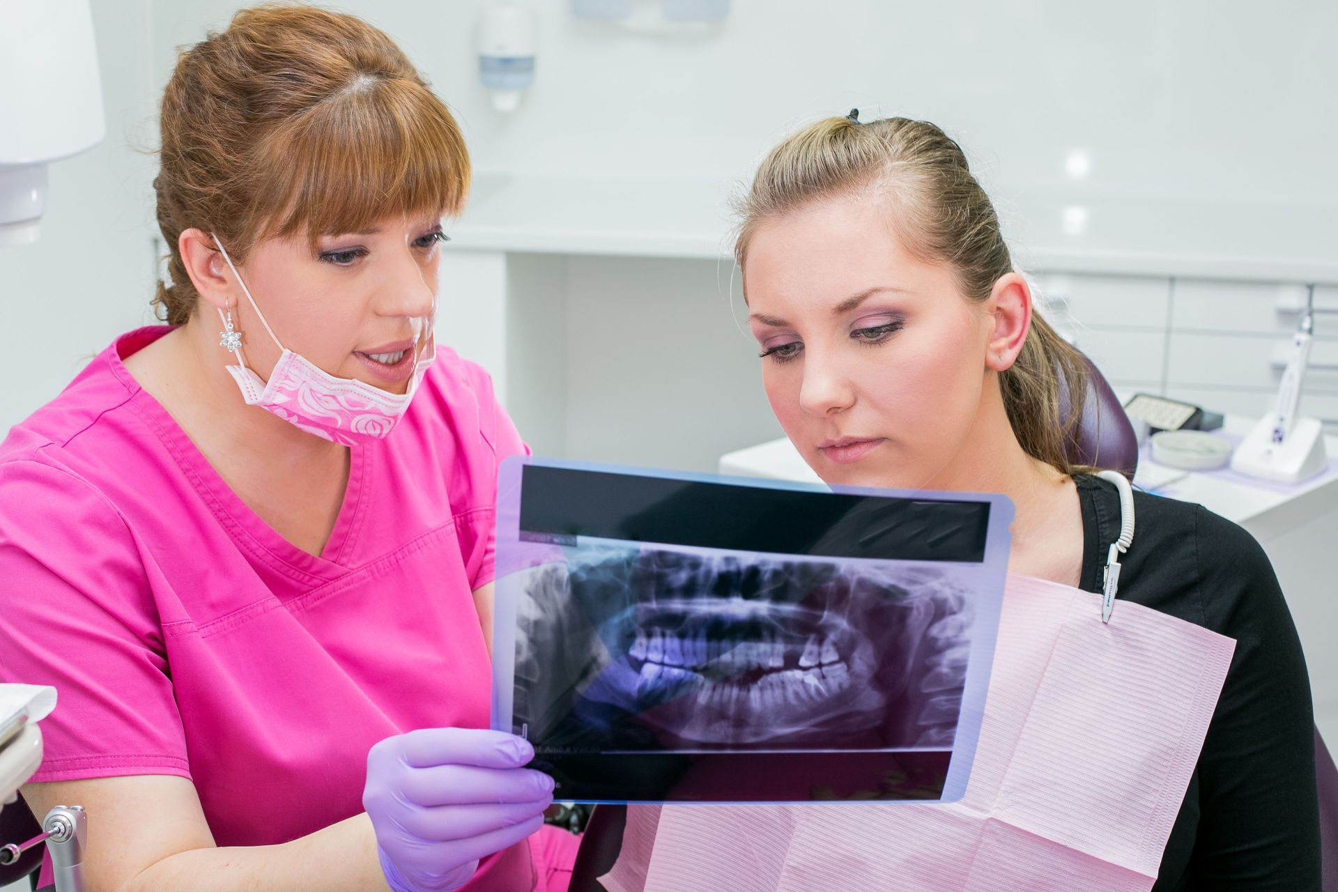 A dentist and patient reviewing a dental X-ray