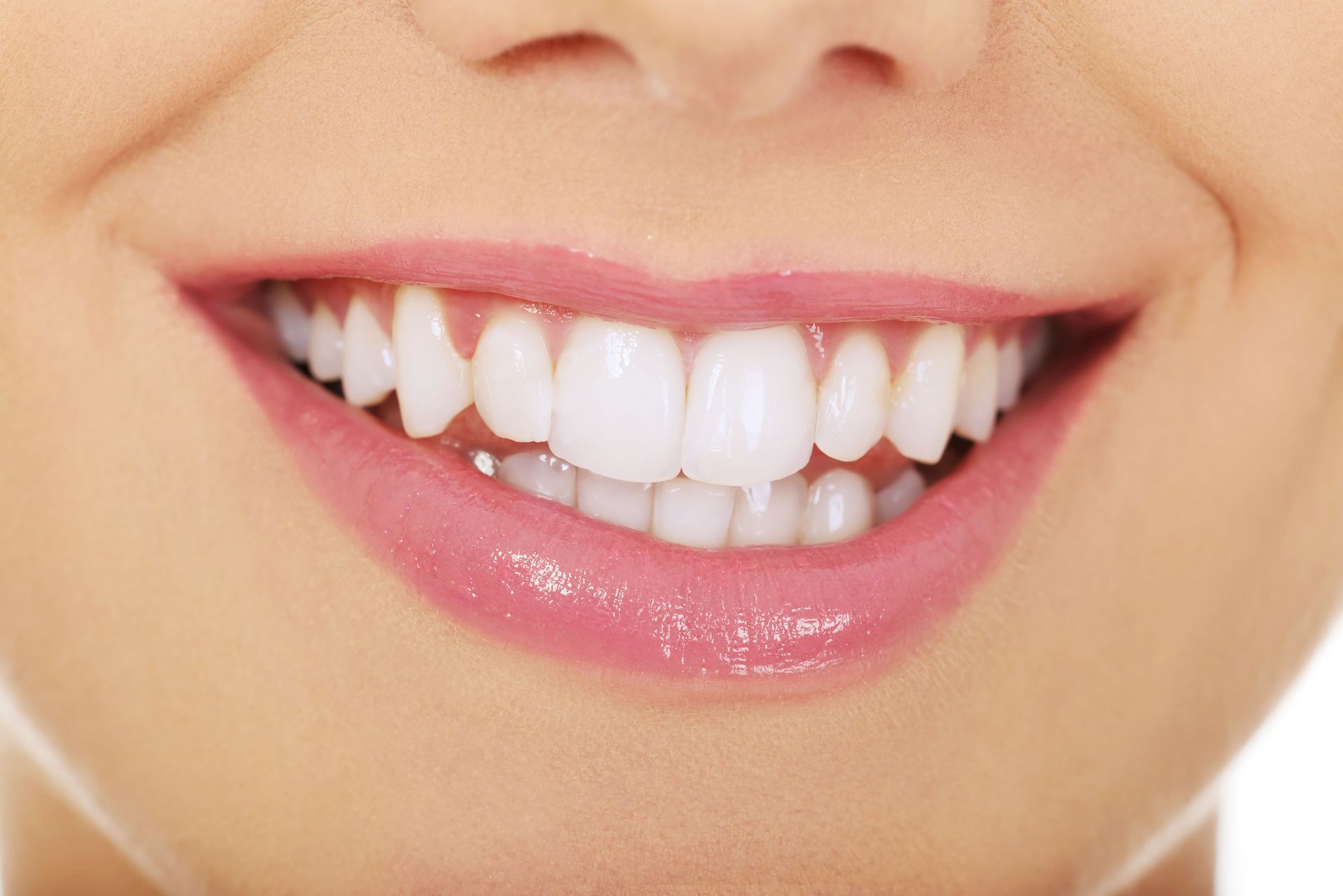 Close-up of a smiling mouth with white teeth and pink lips