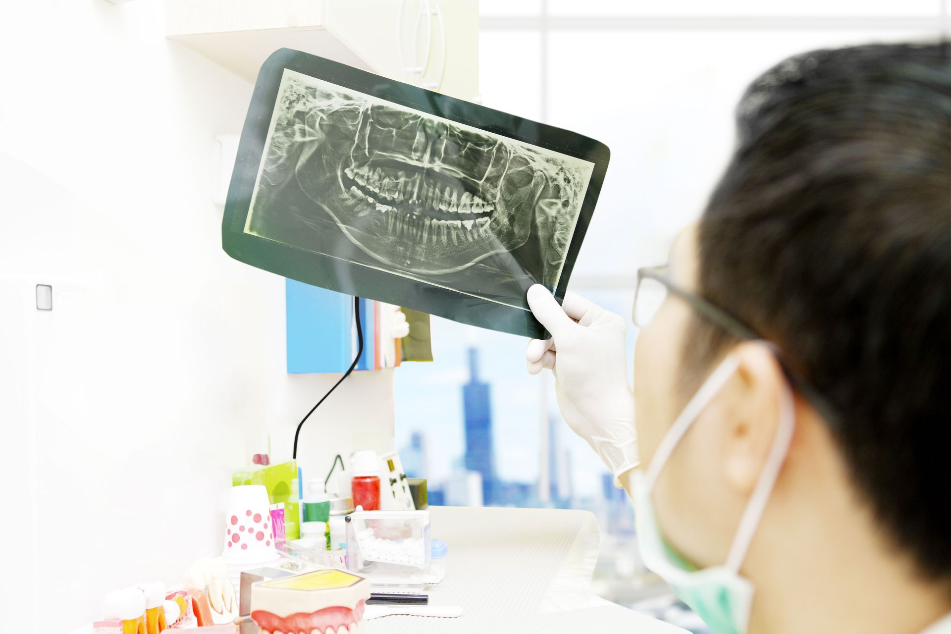 Man holding an X-ray film in a bright clinic room