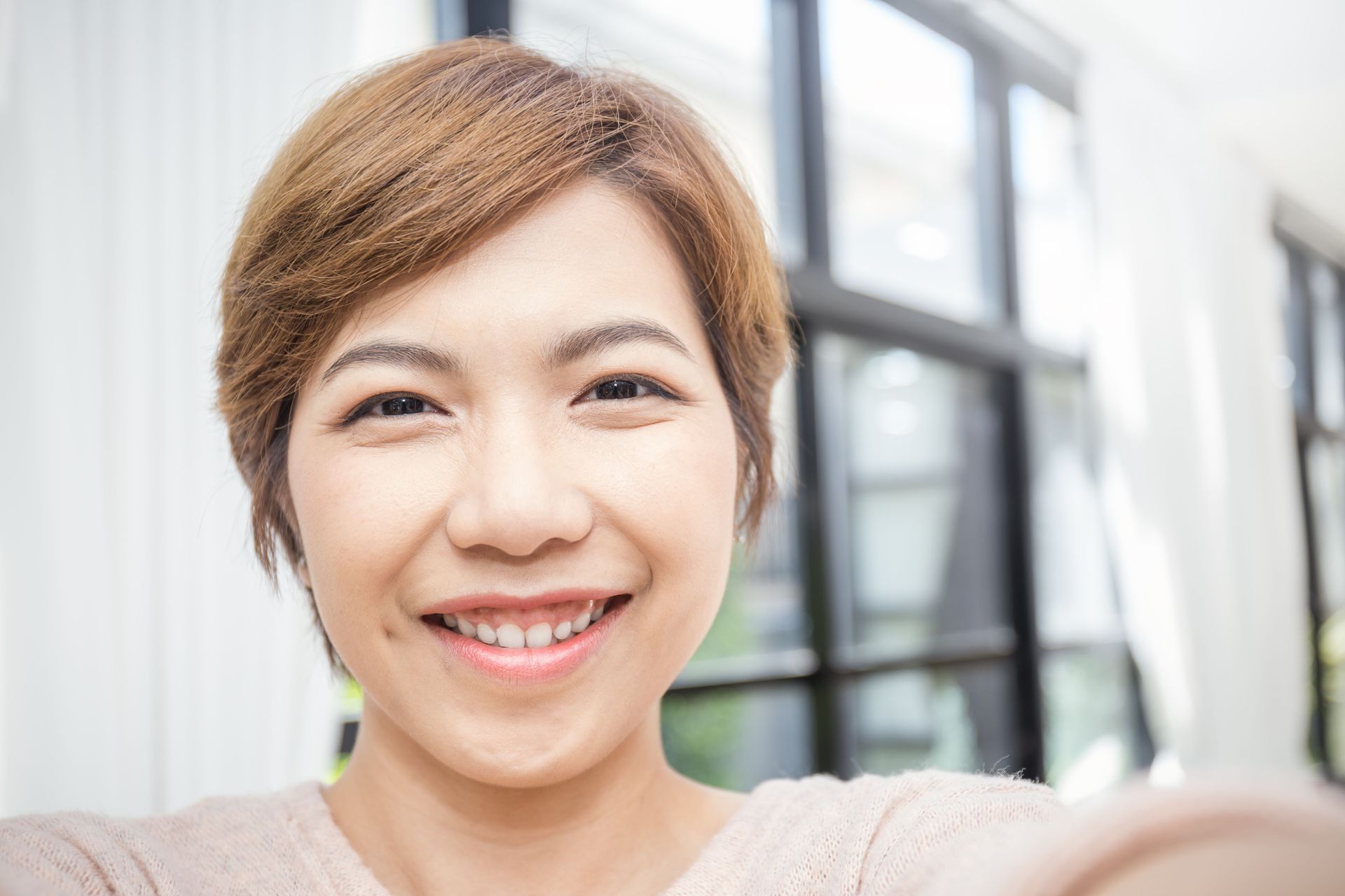 Smiling person taking a selfie indoors