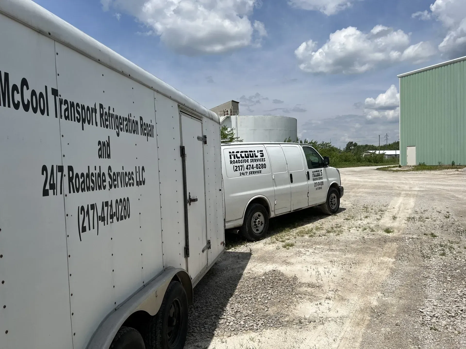 White trailer and van parked on gravel, with text for 