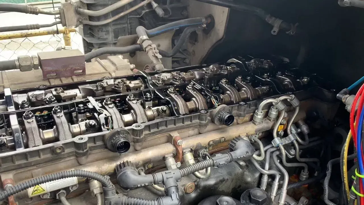Open engine bay, diesel engine components covered in oil.