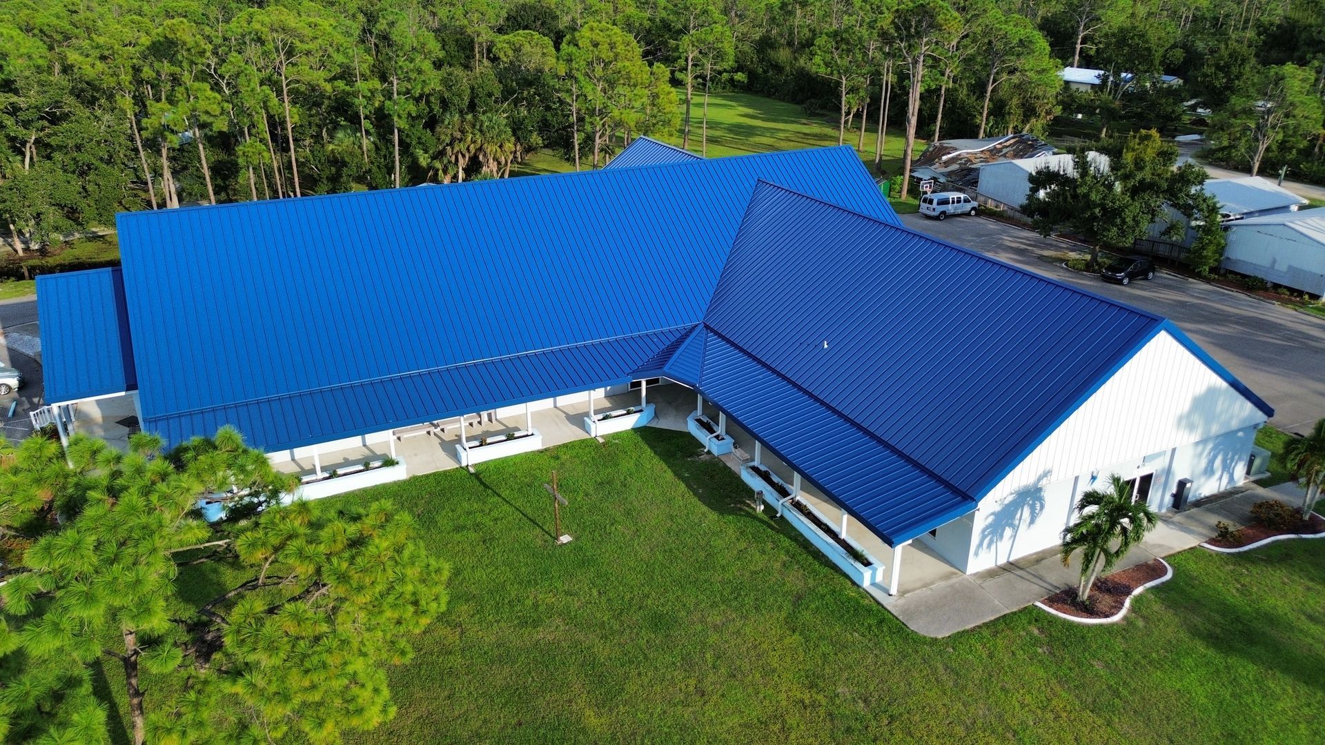 An aerial view of a large building with a blue roof