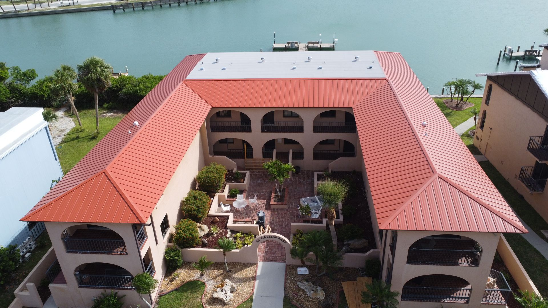 An aerial view of a large building with a red roof