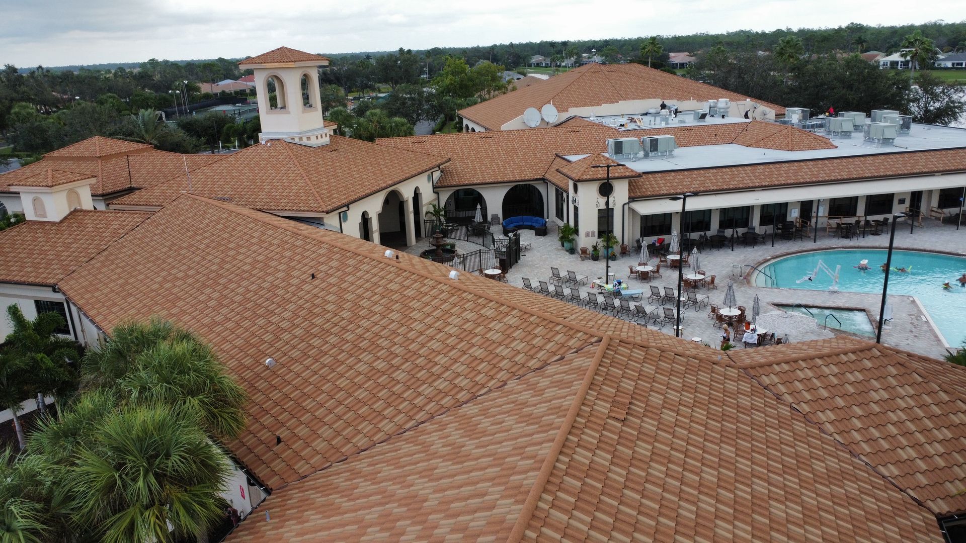 An aerial view of a large building with a pool in the middle of it.