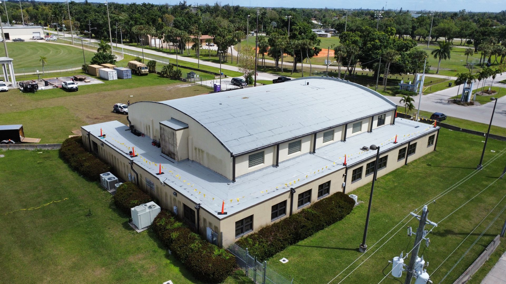 An aerial view of a large building with a white roof
