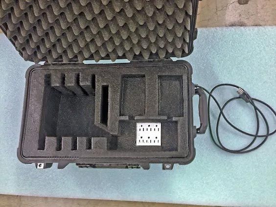 A black foam case with a cord attached to it