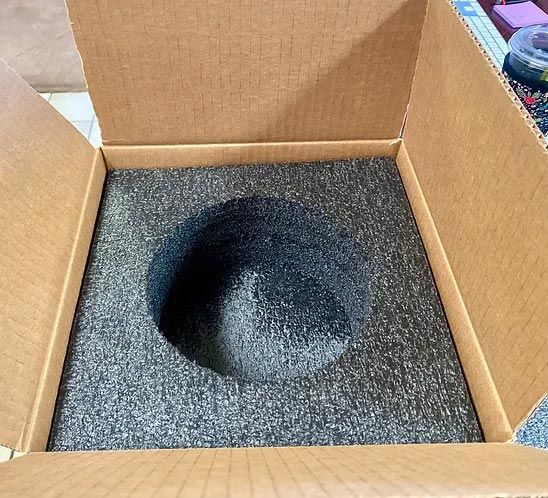 A cardboard box with a hole in the middle of it