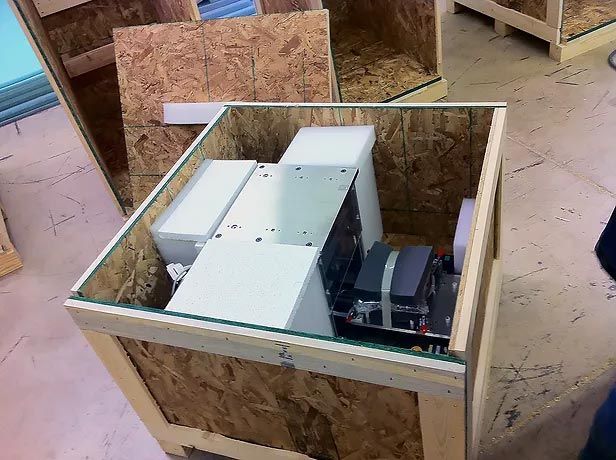 A wooden crate with a glass top has a white box inside of it