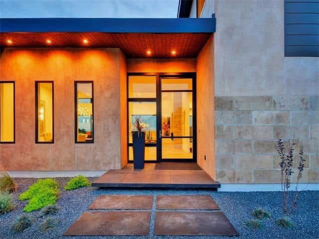 The front of a modern house with a large glass door.