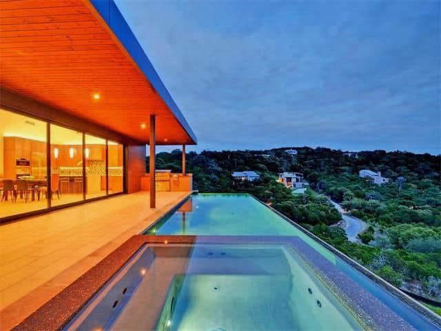 A large house with a large swimming pool in front of it.