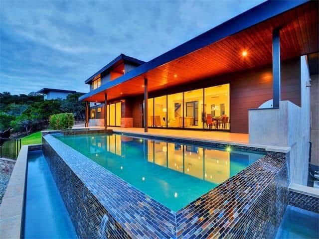 A large house with a swimming pool in front of it.