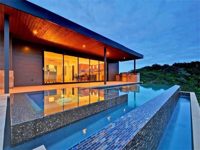 A large house with a swimming pool in front of it.