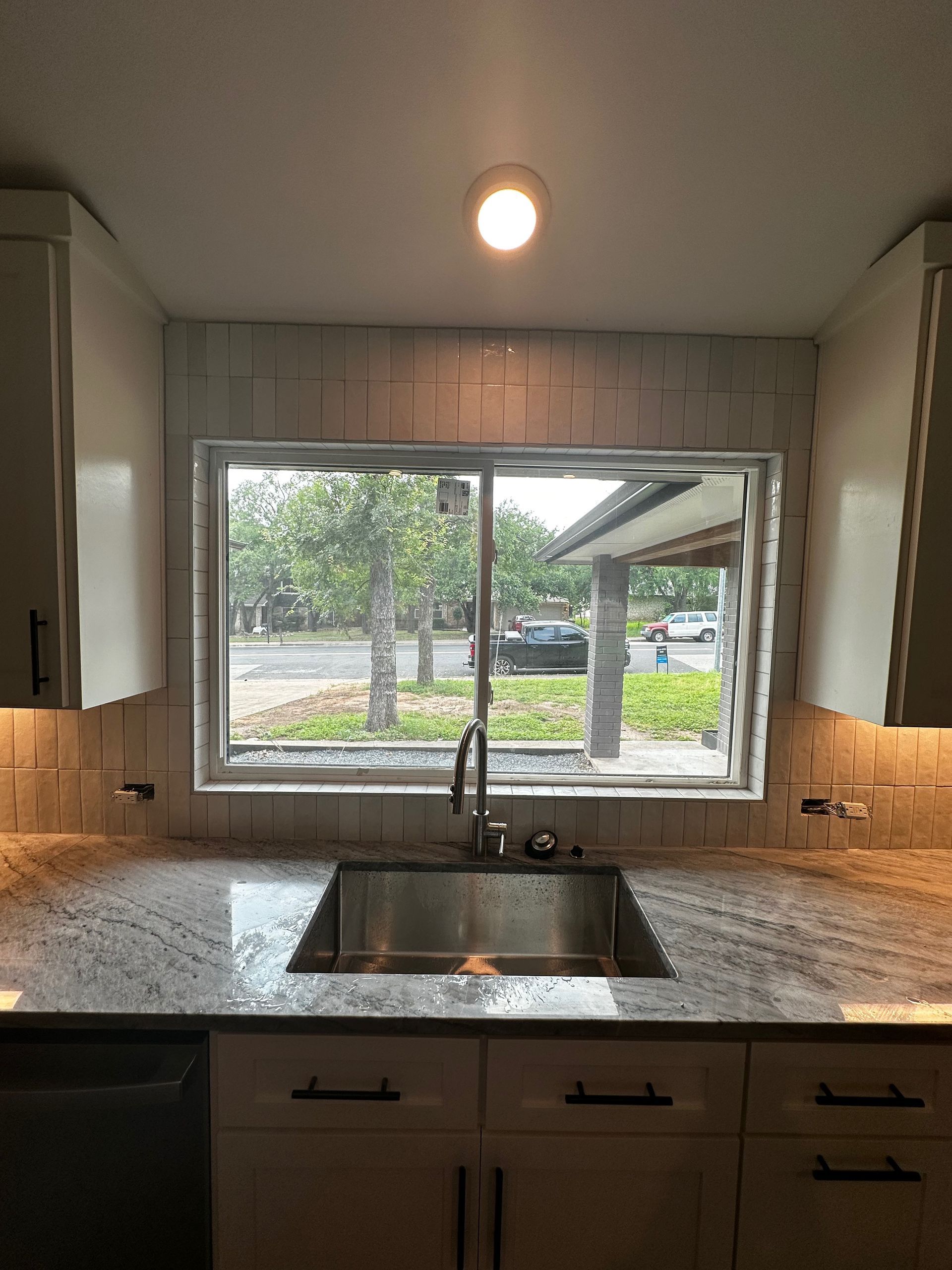 A kitchen with a sink and a large window.