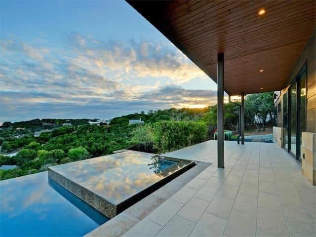 A house with a swimming pool and a view of trees.