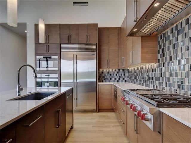 A kitchen with stainless steel appliances and wooden cabinets.