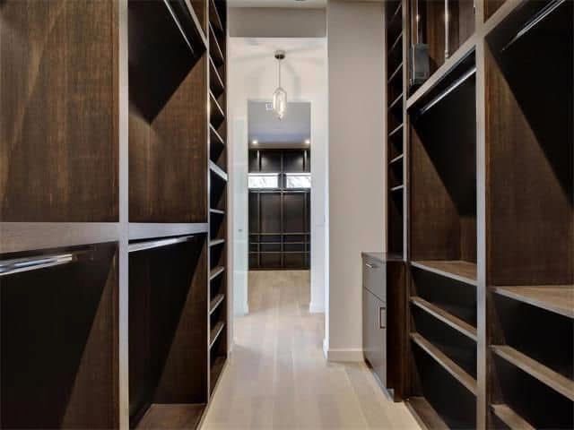A walk in closet with lots of shelves and drawers.