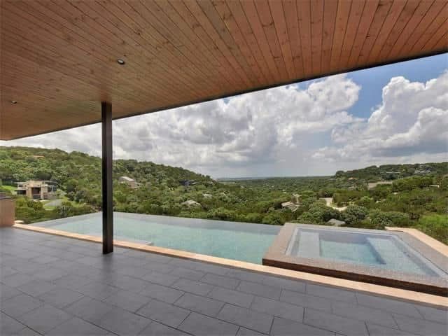 A large swimming pool with a view of a valley.