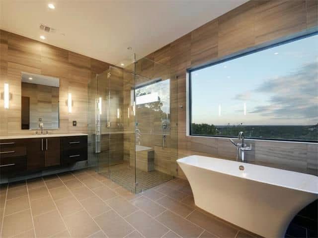 A bathroom with a tub, sink, mirror, and walk in shower.