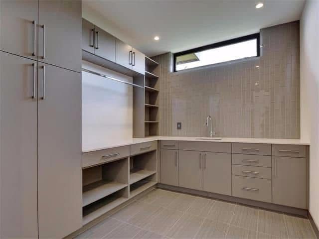 A kitchen with lots of cabinets and drawers and a window.