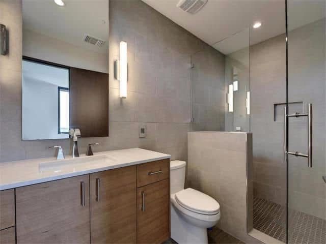 A bathroom with a toilet a sink and a mirror.