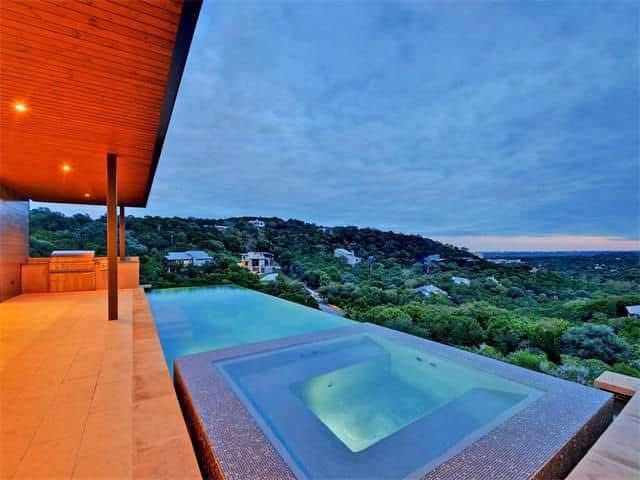 An infinity pool with a view of a hillside.