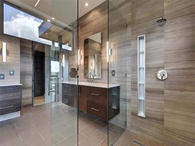 A bathroom with a walk in shower and two sinks.