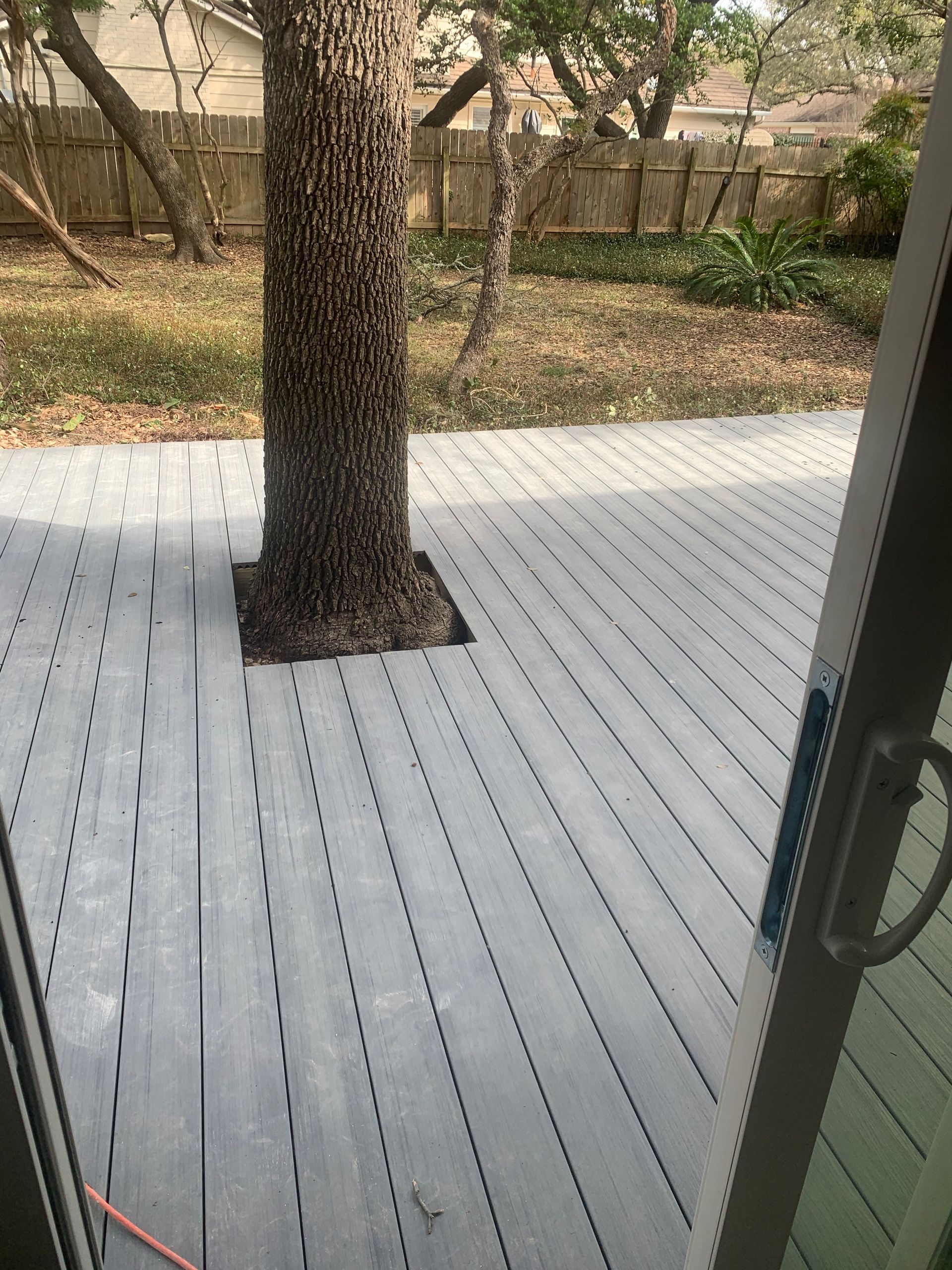 A wooden deck with a tree in the middle of it.