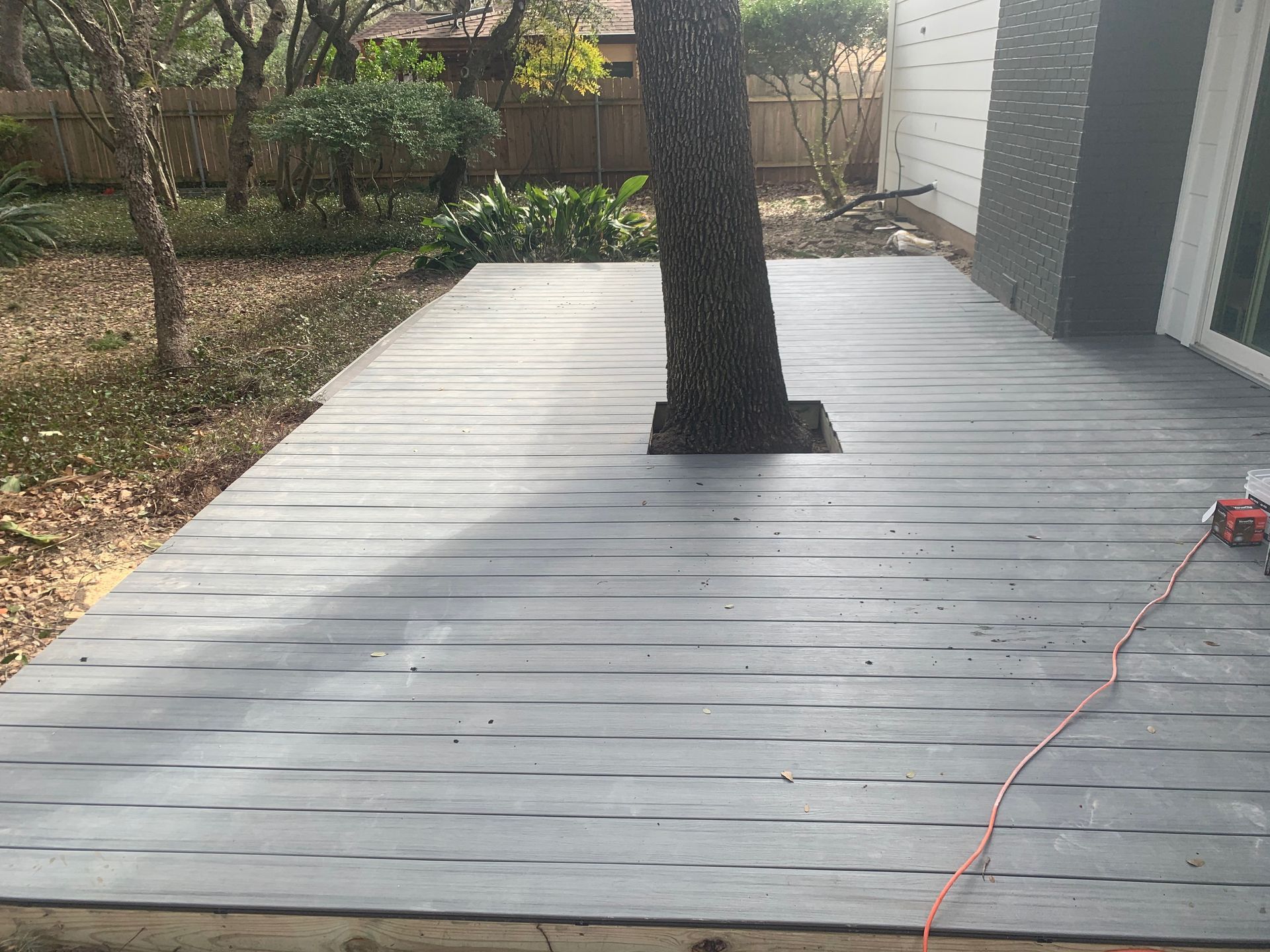 A wooden deck with a tree in the middle of it.