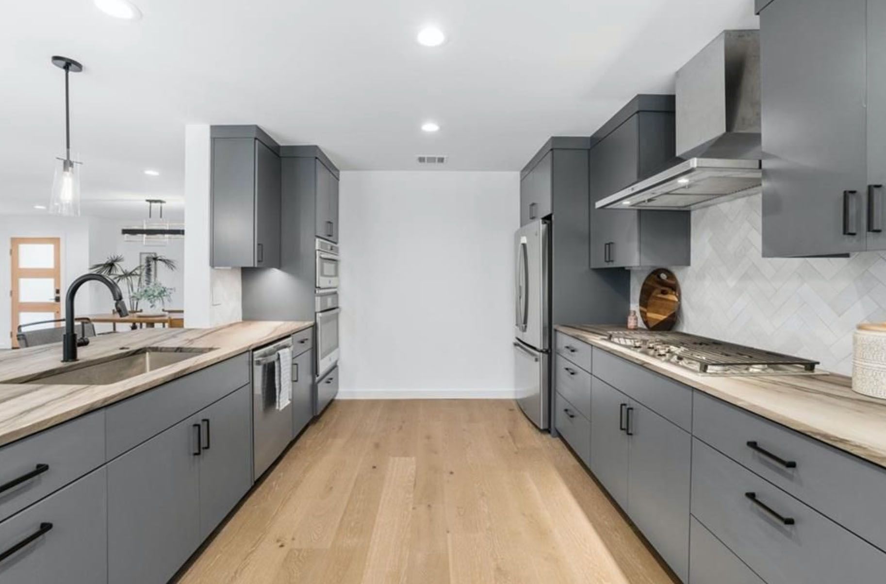 A kitchen with gray cabinets and stainless steel appliances.