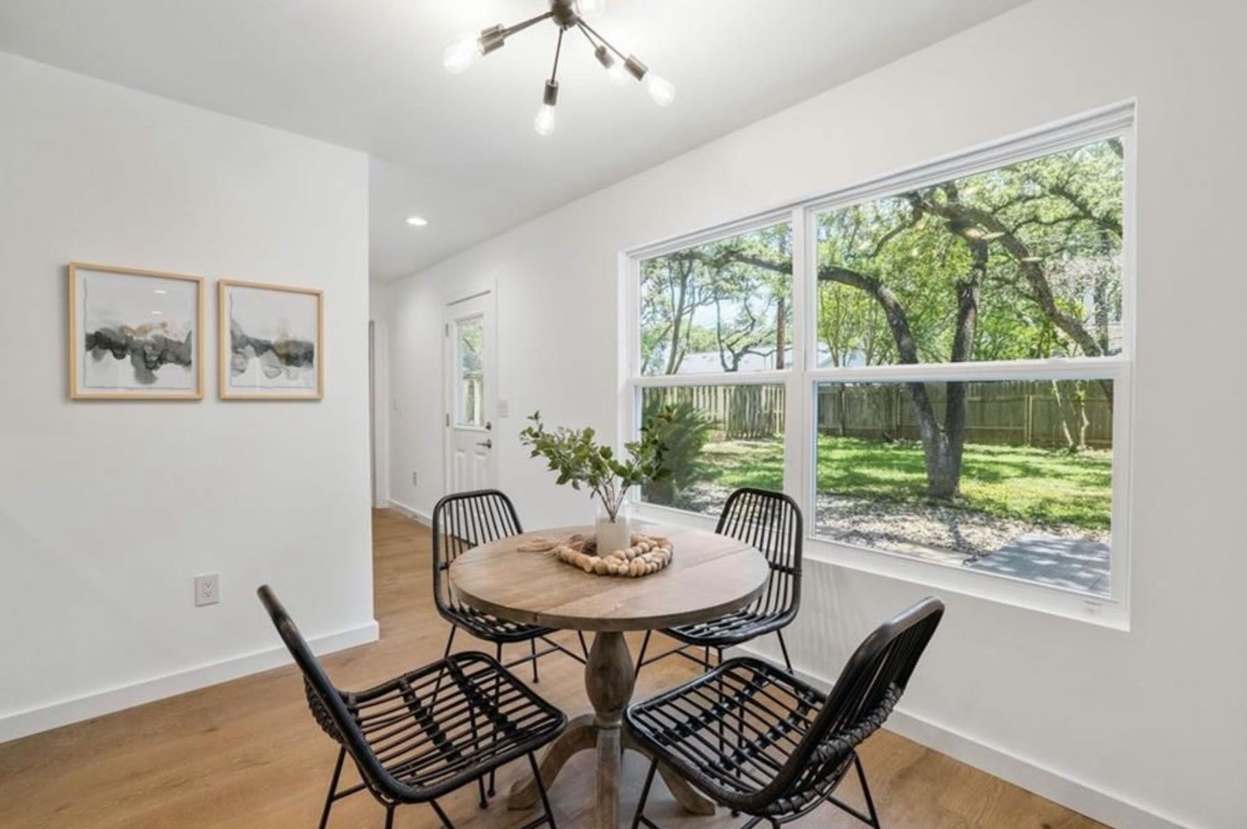 A dining room with a table and chairs and a large window.