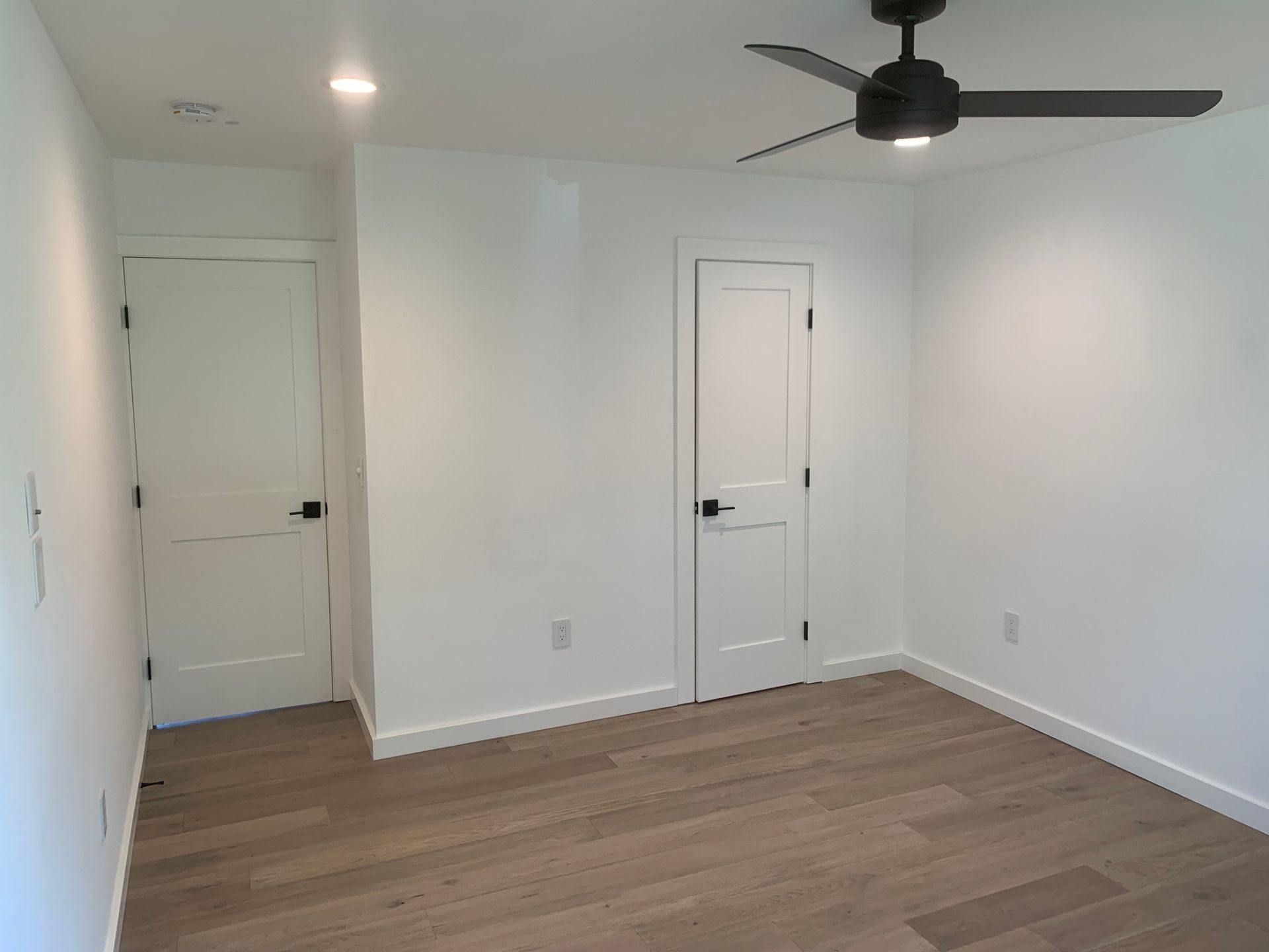 There is a ceiling fan in the corner of the room.