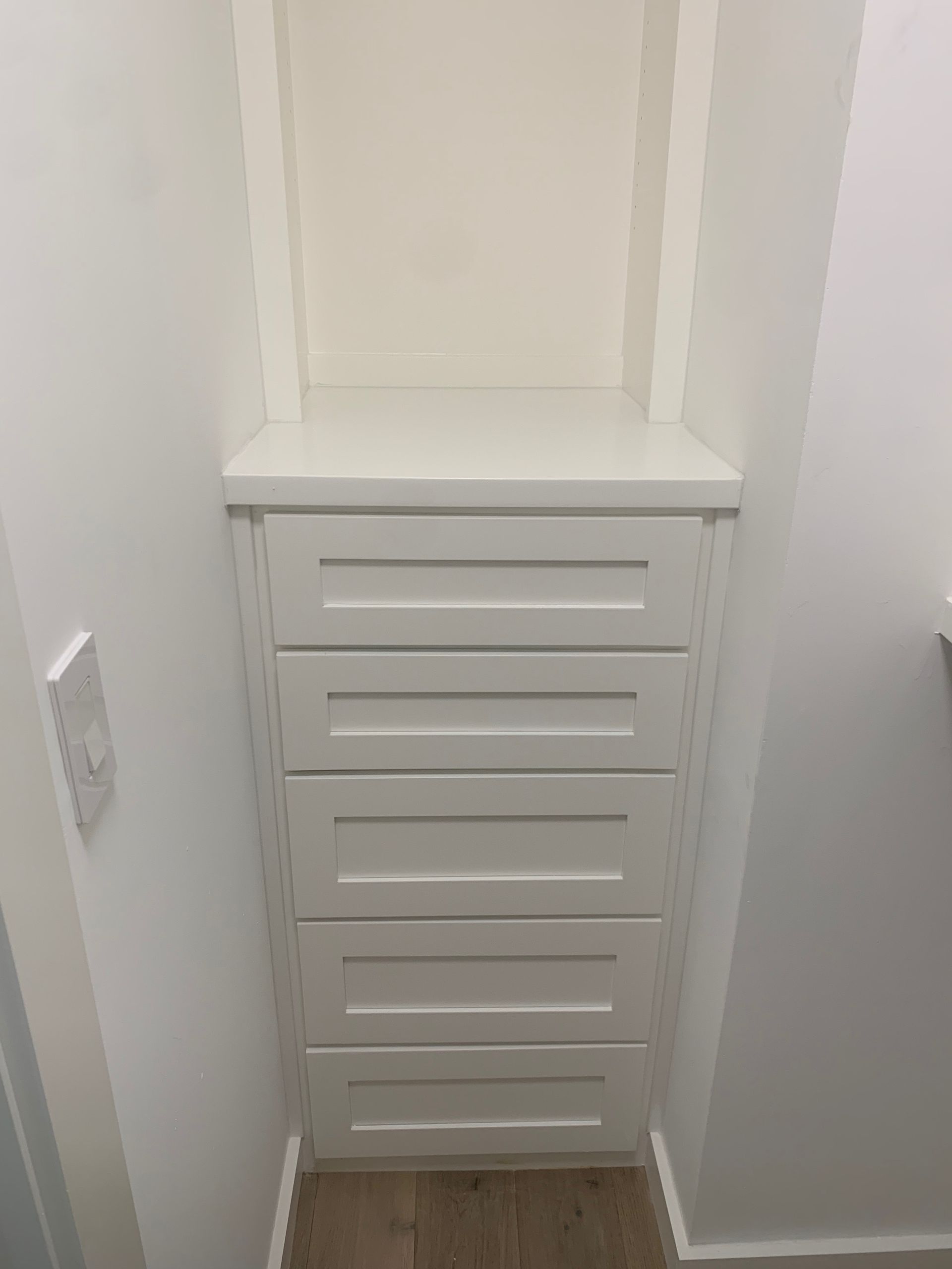A closet with a shelf and drawers in it.