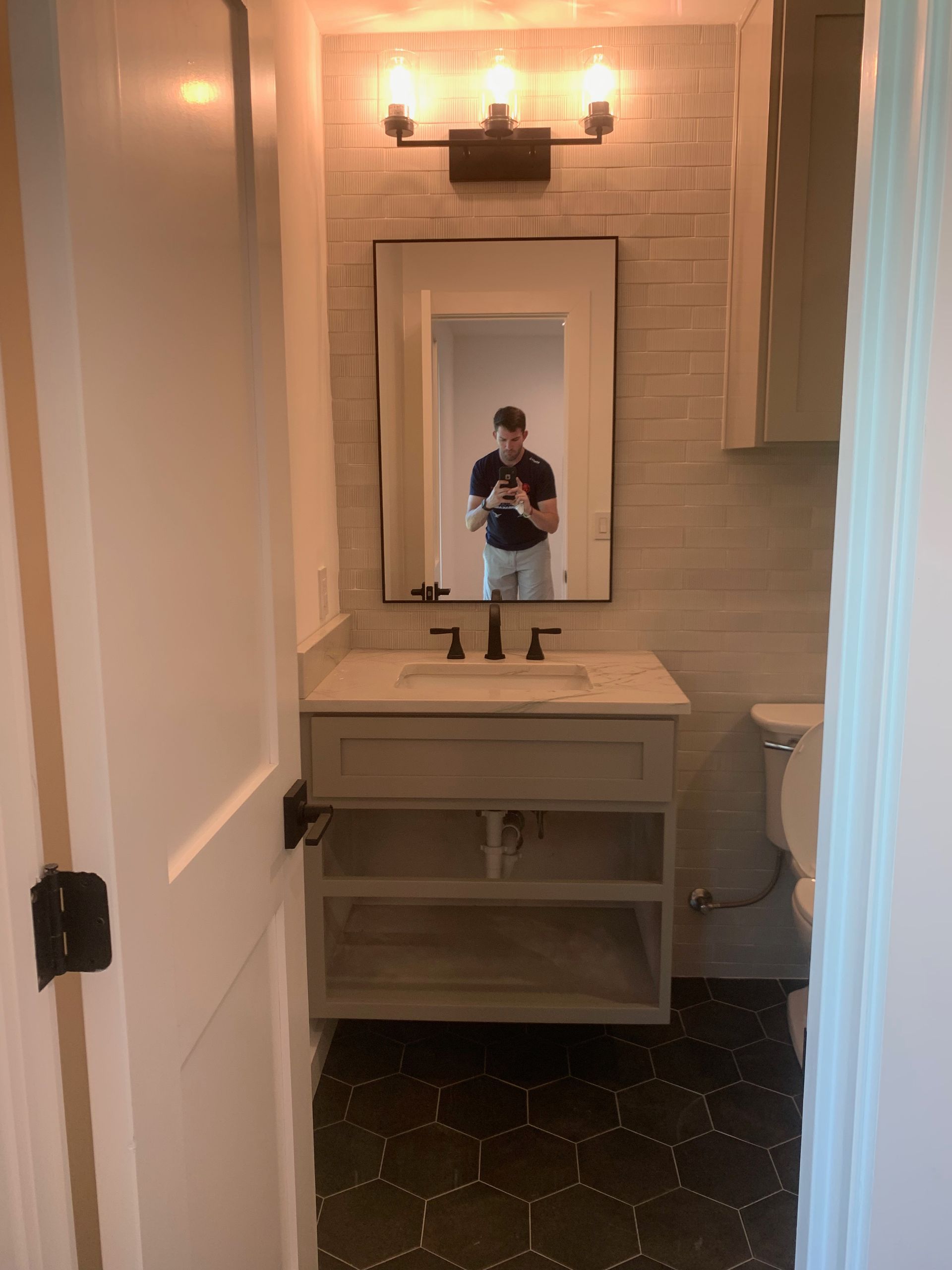 A man is taking a picture of himself in a bathroom mirror.