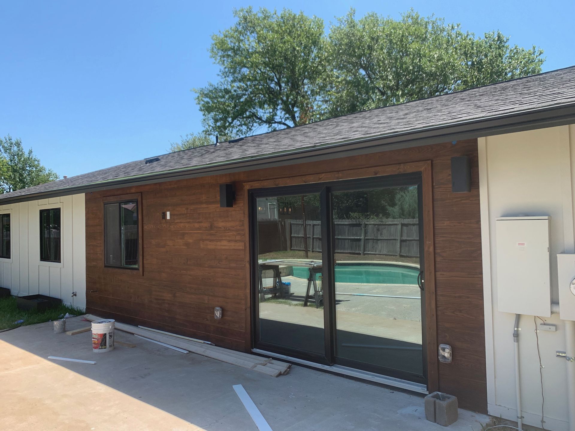 A house with a sliding glass door and a pool in the backyard.