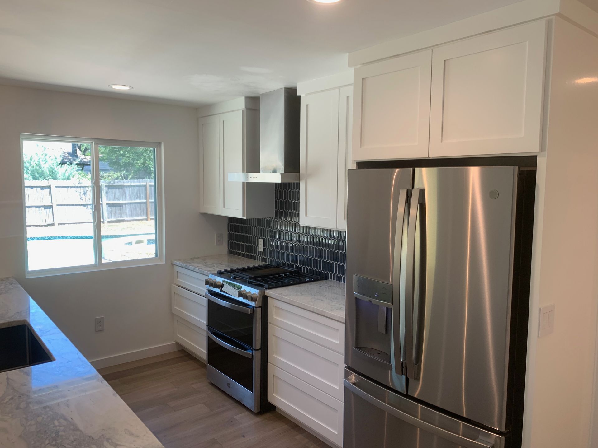 A kitchen with stainless steel appliances and white cabinets.