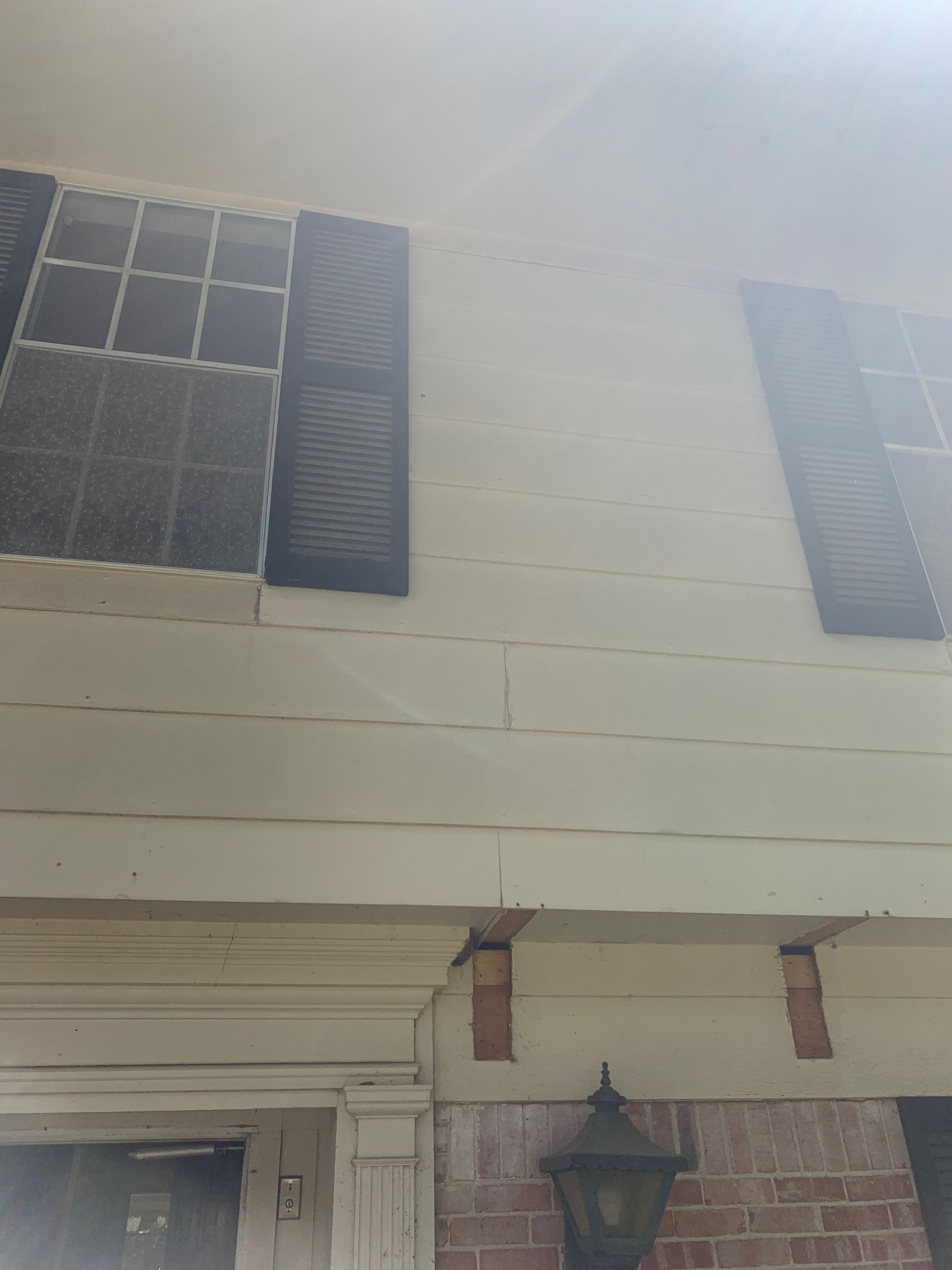 A white house with black shutters on the windows.