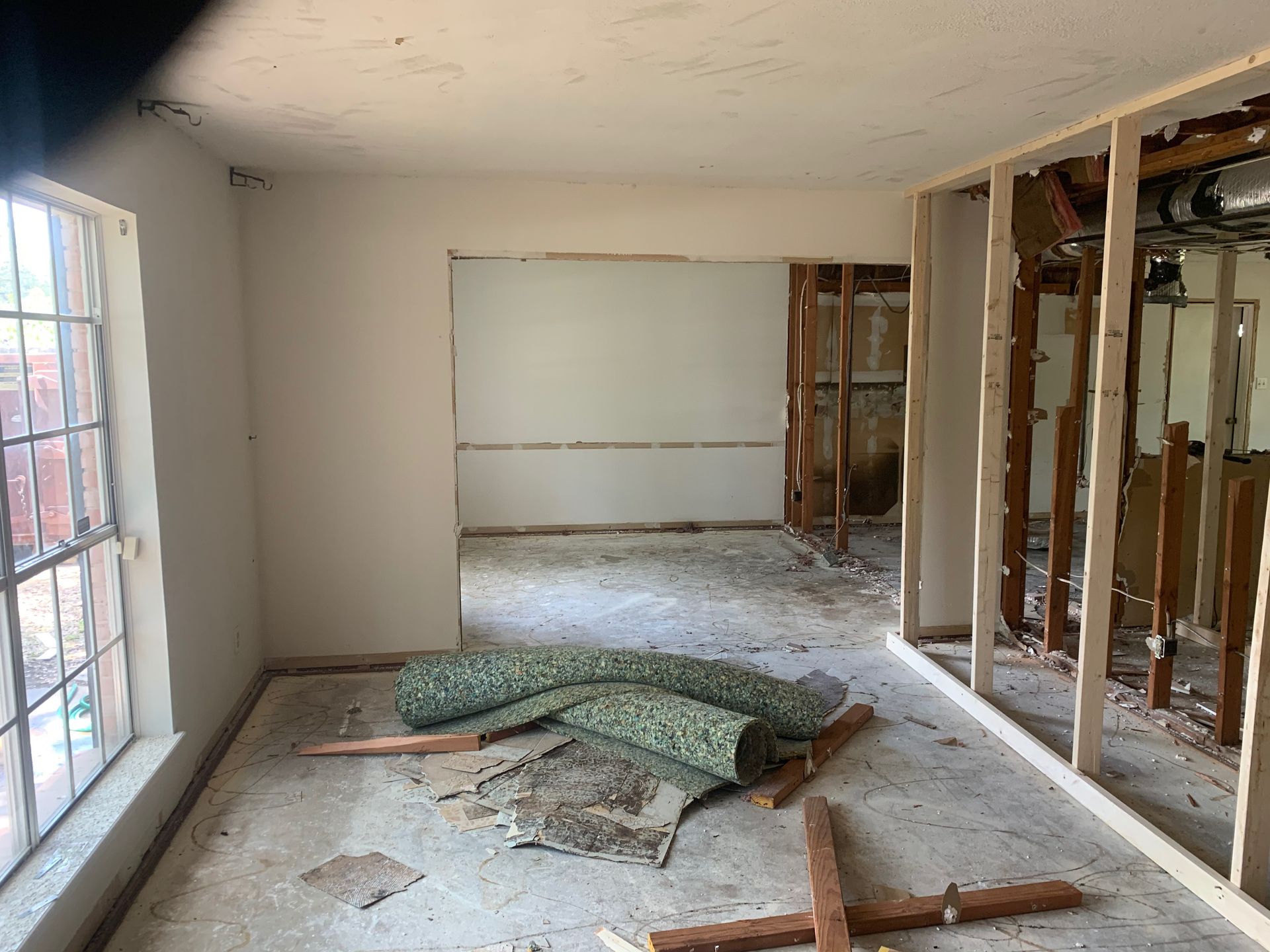 A room with a lot of windows and a rug on the floor.