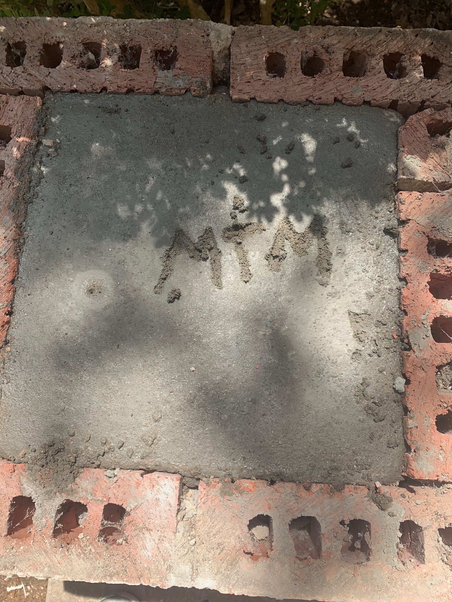 A brick wall with a piece of concrete in the middle.