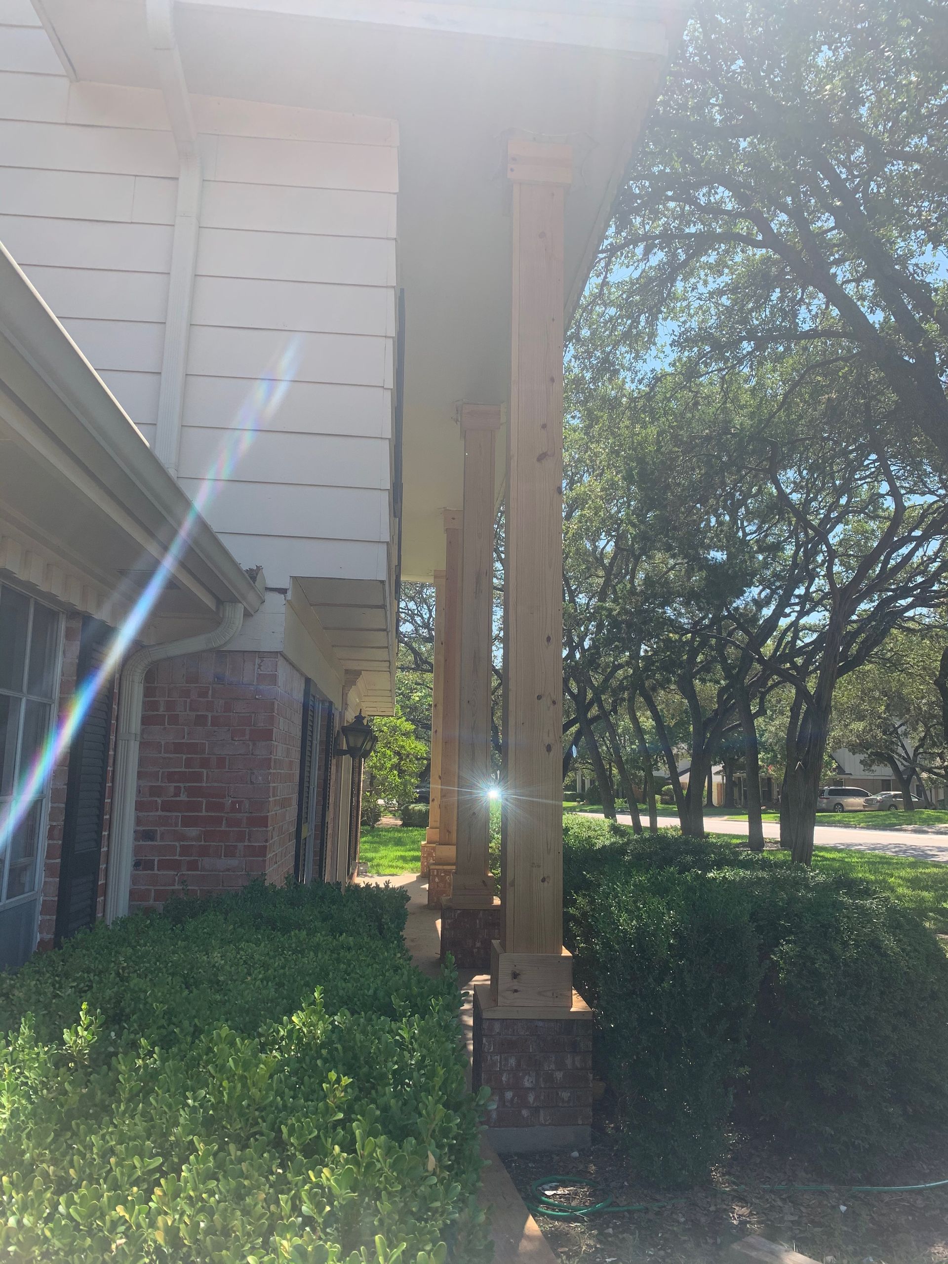 A house with a porch and trees in front of it.