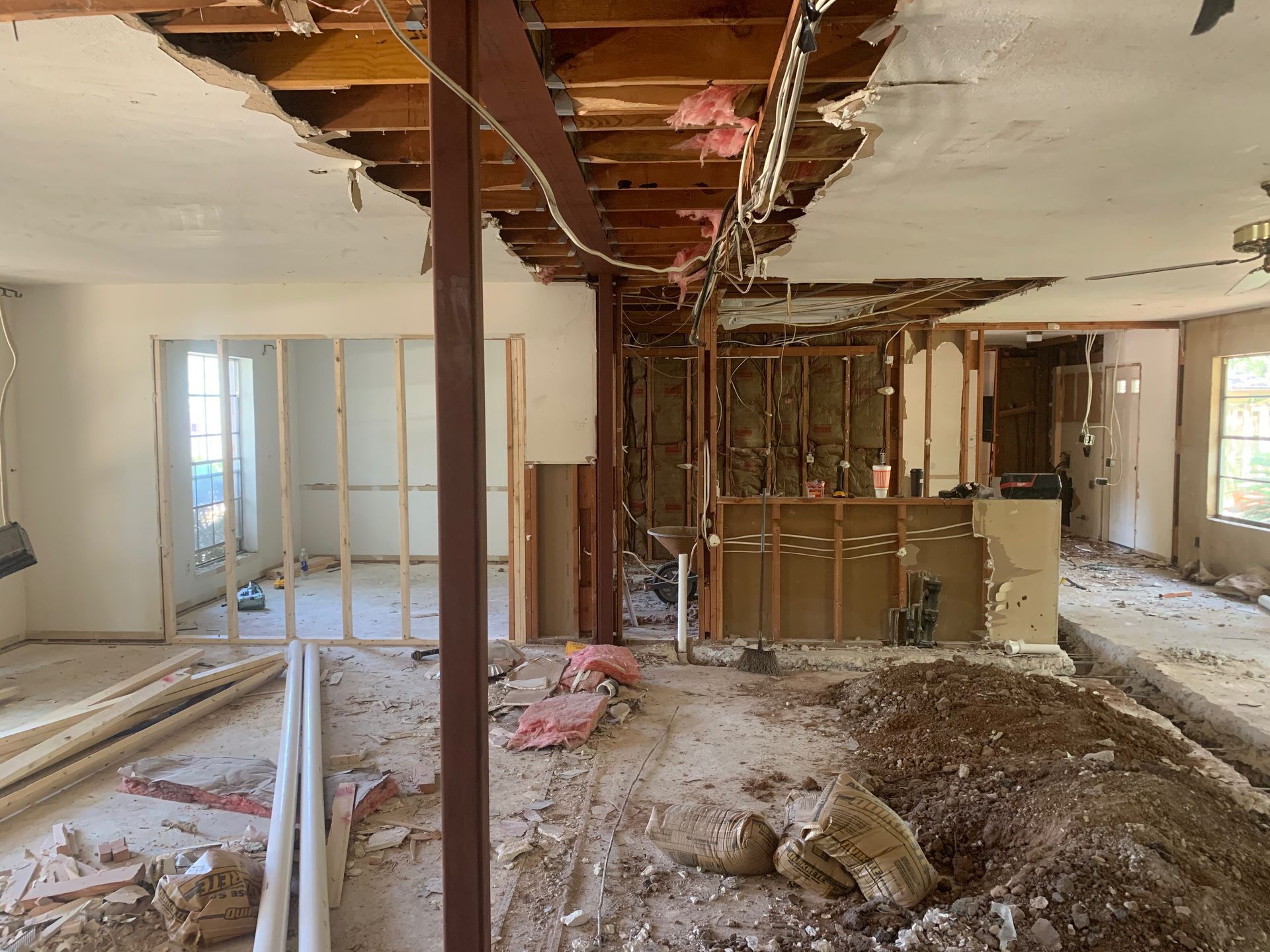 A large room with a hole in the ceiling is being remodeled.