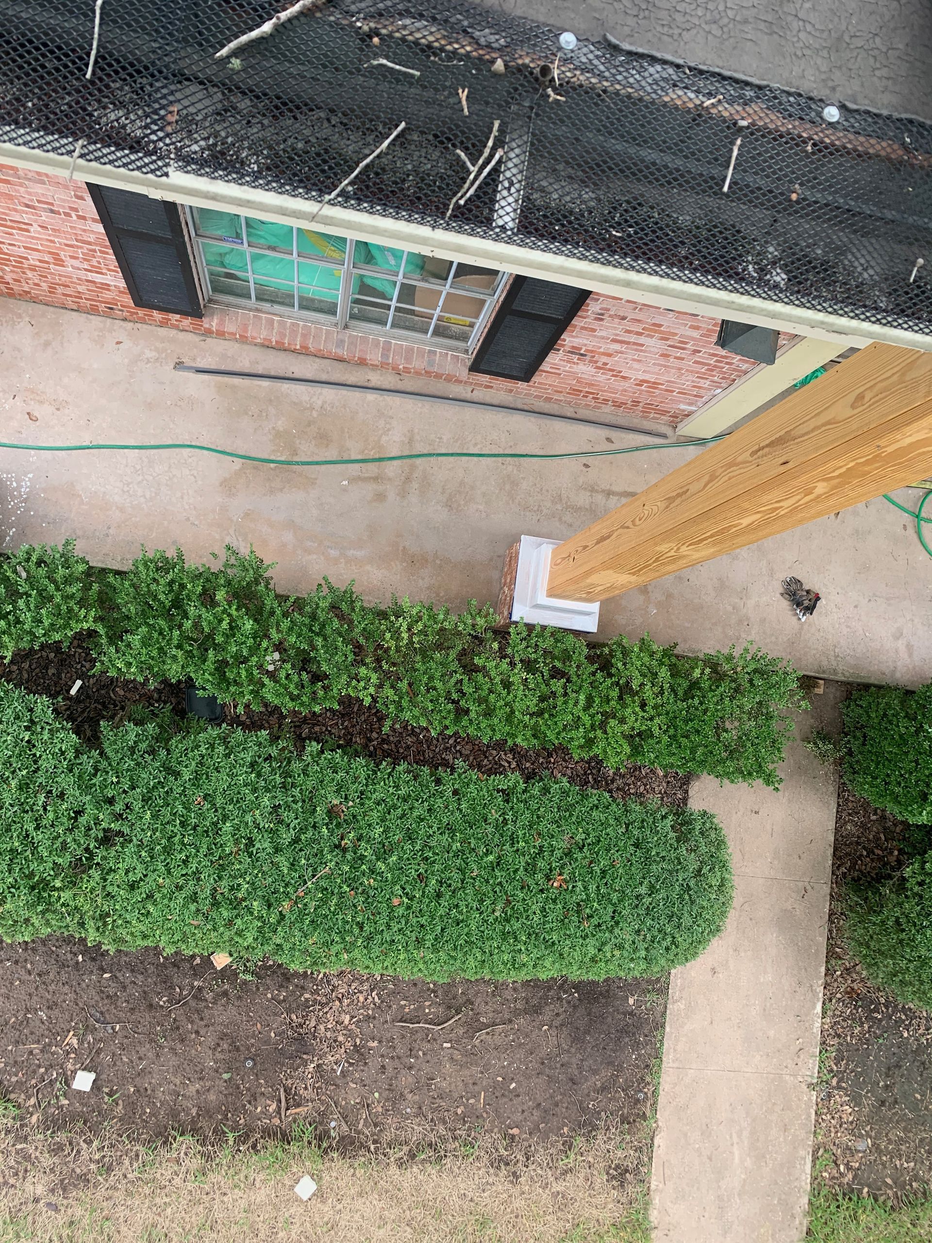 An aerial view of a house with a wooden post in front of it.