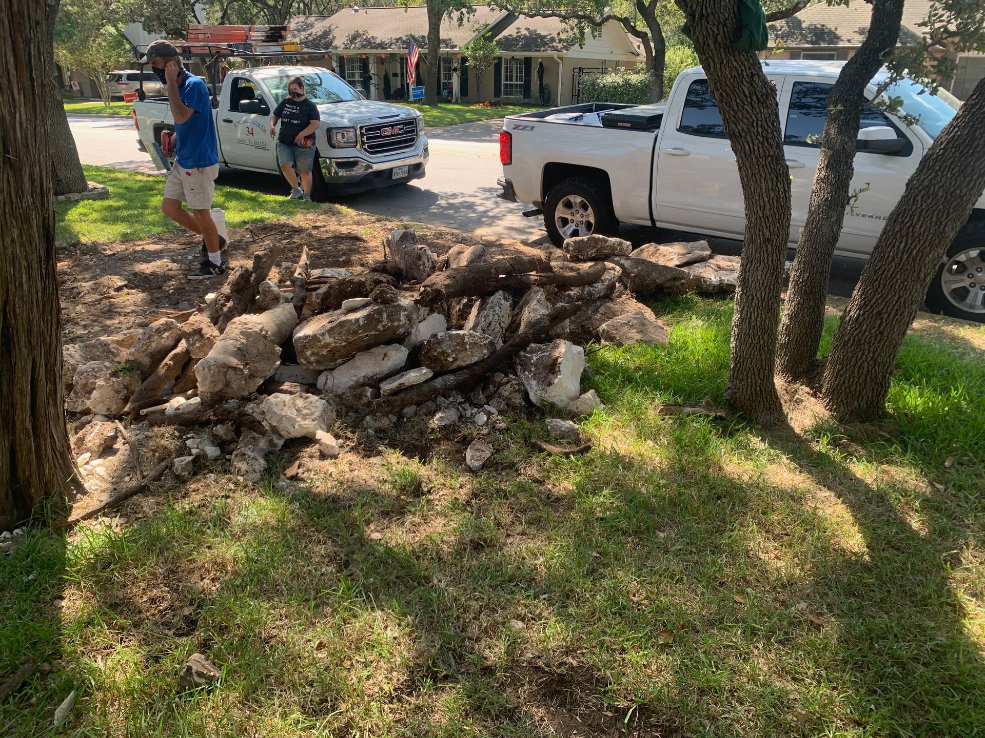 A man is standing next to a pile of rocks next to a truck.