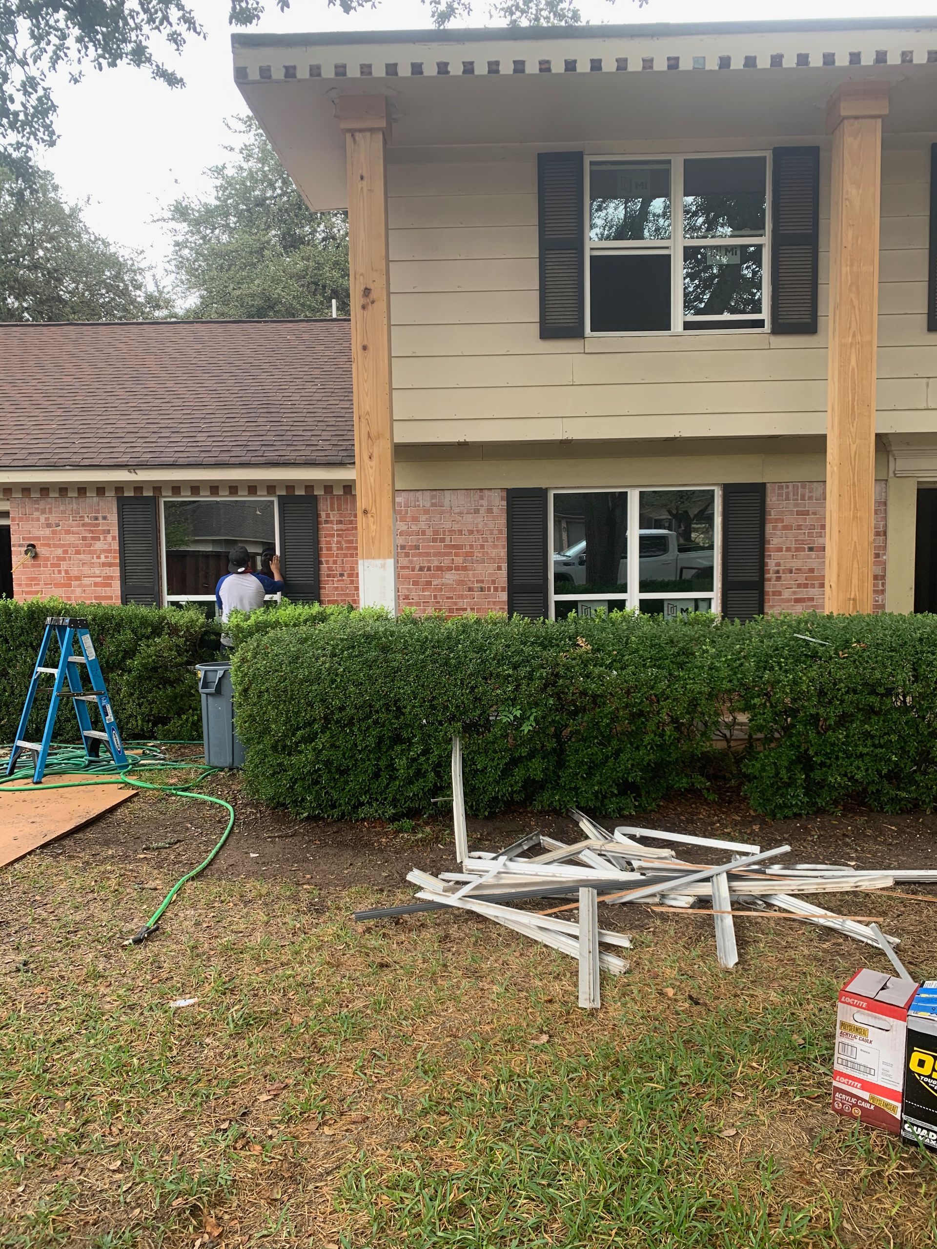 A man is standing in front of a house that is being remodeled.