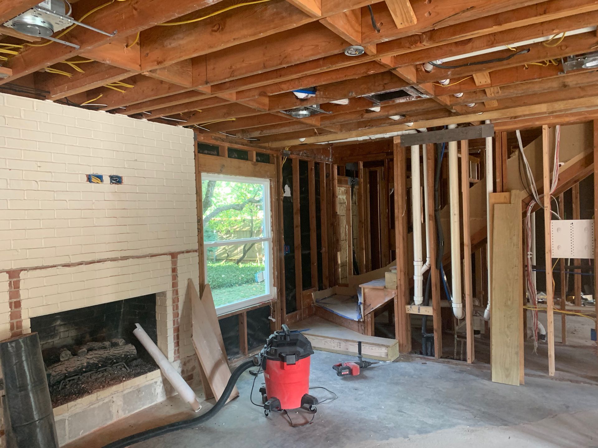 A vacuum cleaner is sitting in the middle of a room under construction.