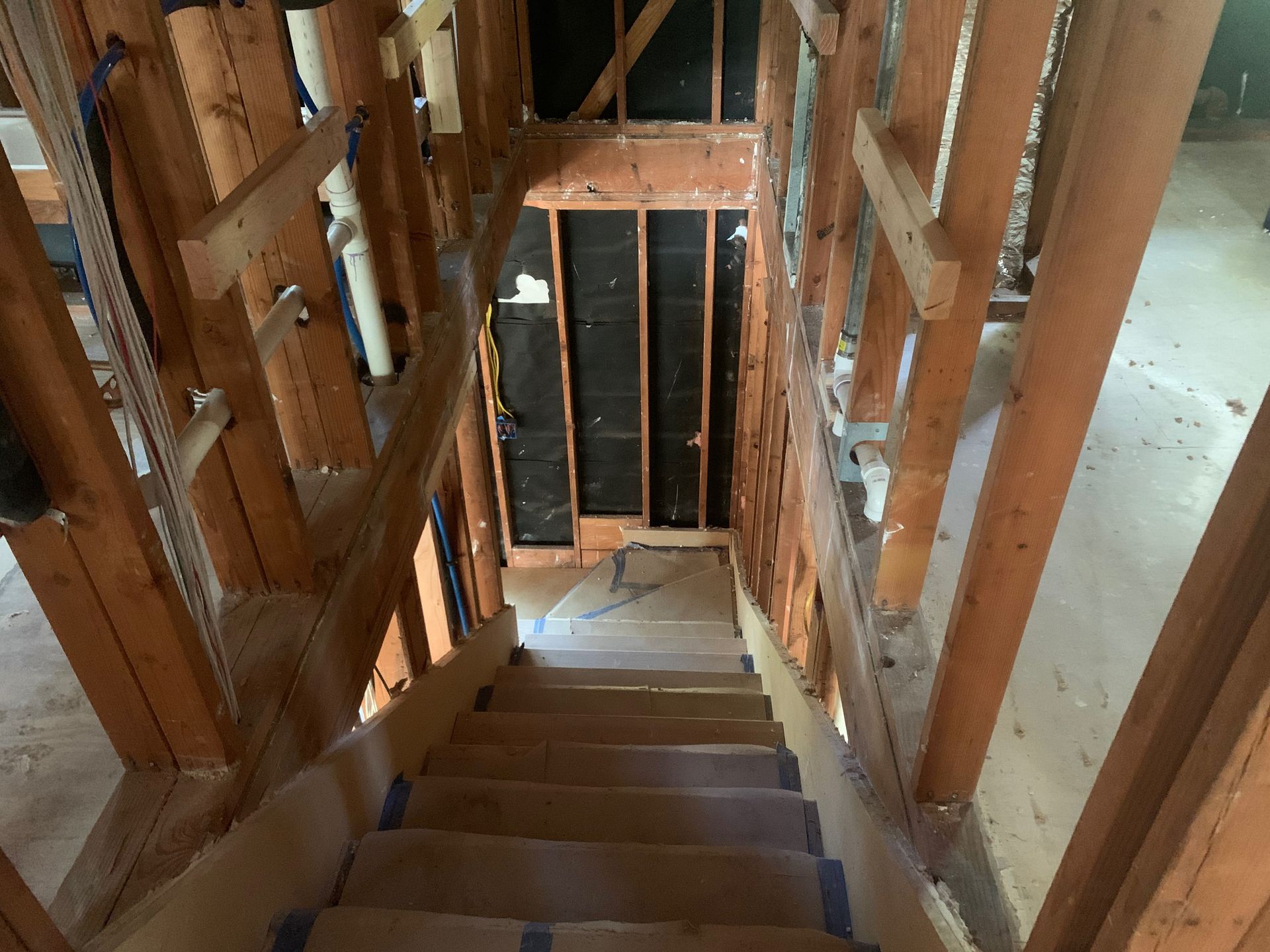 A wooden staircase in a house under construction.