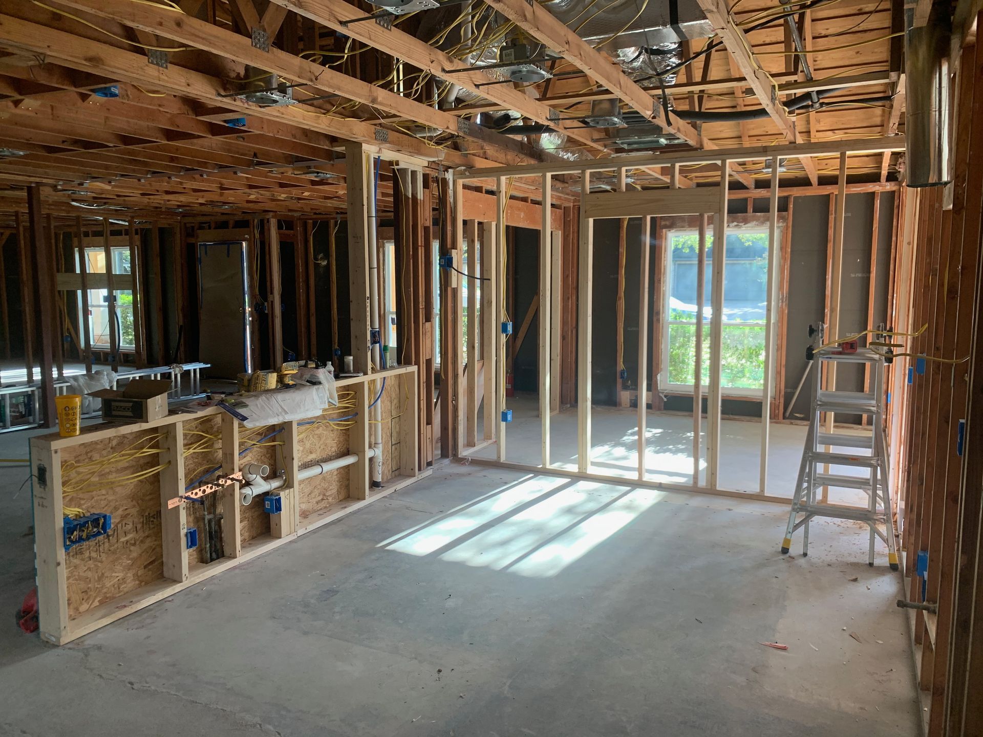 A room in a house under construction with a ladder.