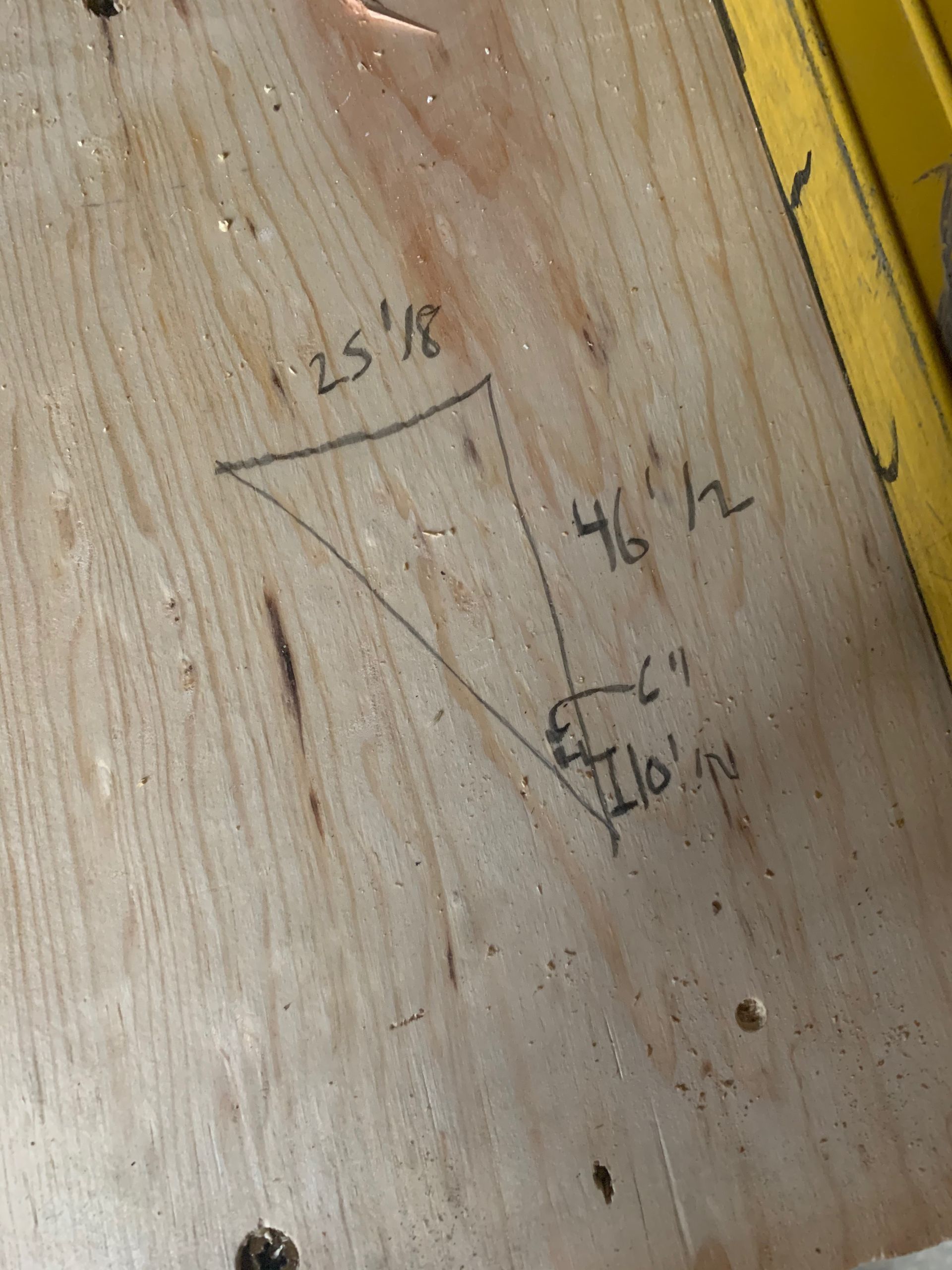 A piece of wood with a triangle drawn on it.