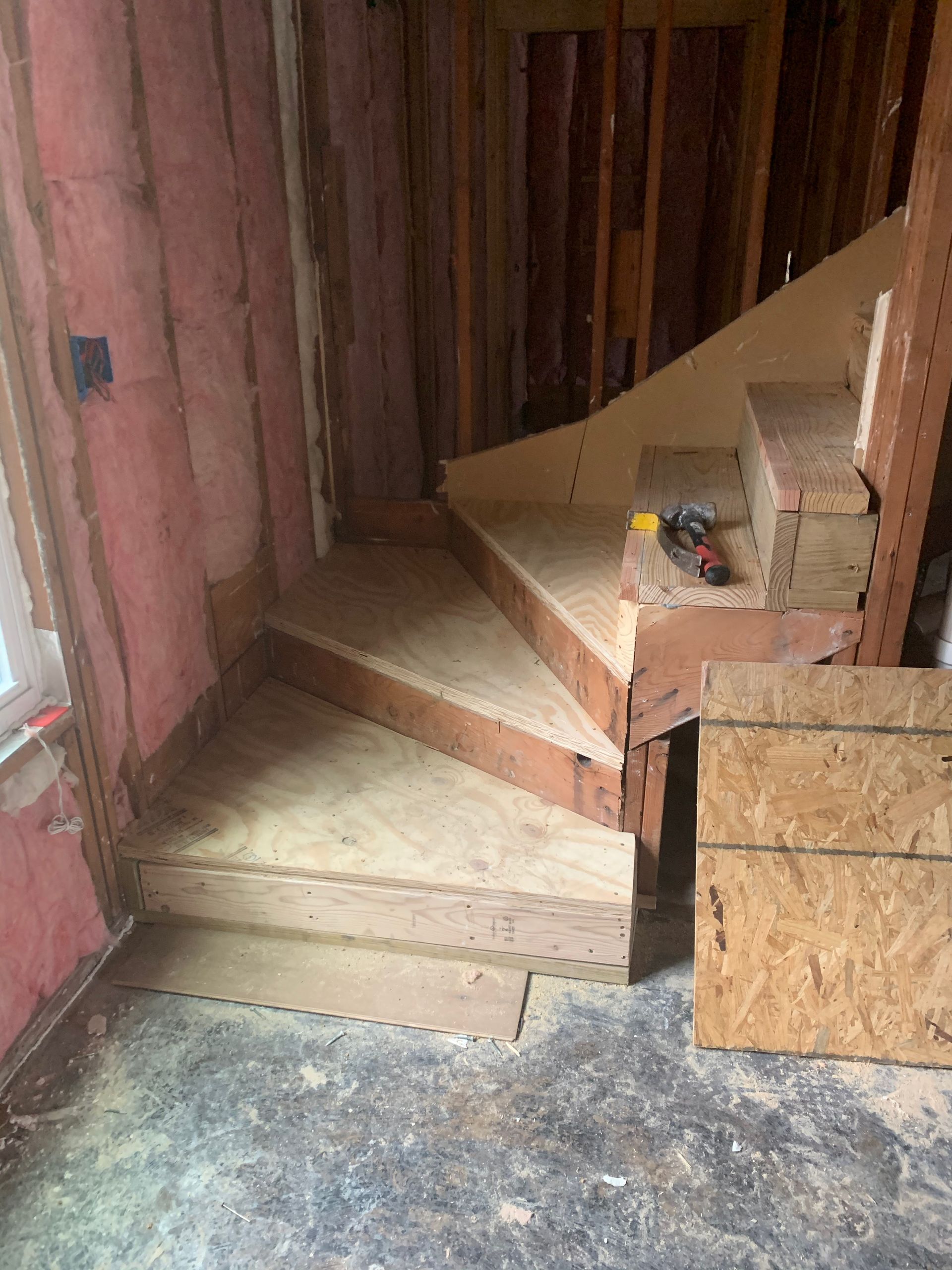 A wooden staircase is being built in a room.