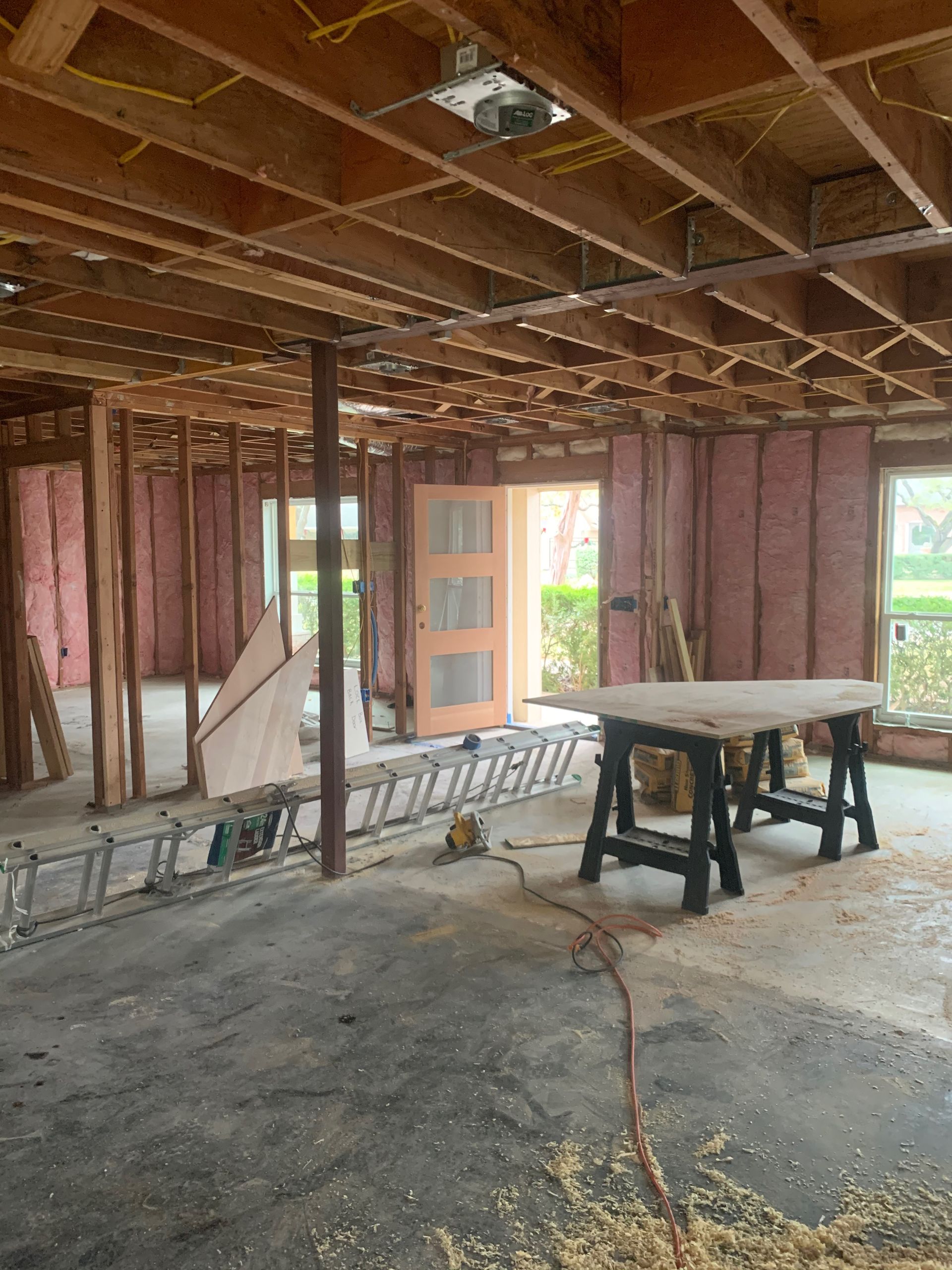 A room under construction with a table and a ladder.